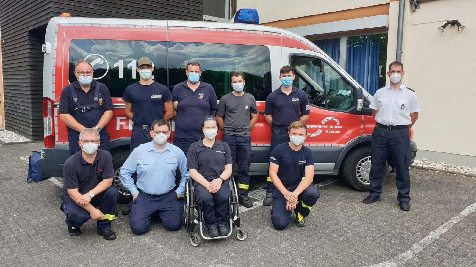 Mitglieder der Feuerwehr mit Masken vor Feuerwehrauto der VG Ruwer