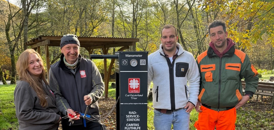 Vier Personen präsentieren die Radservicestation