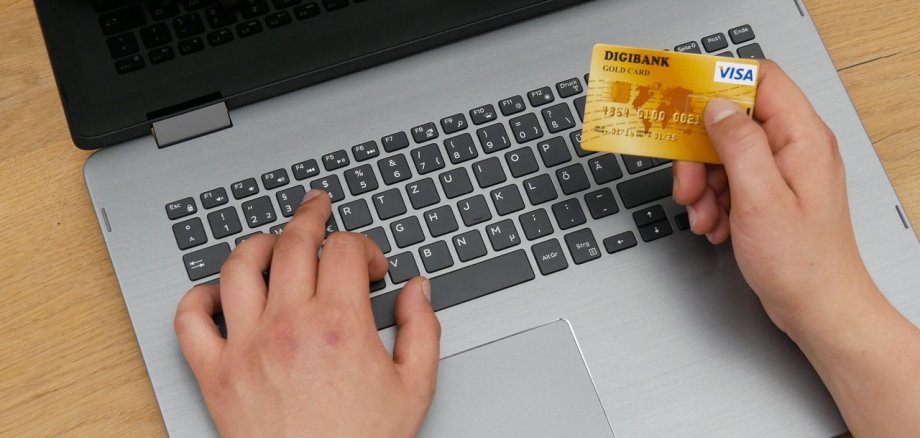 Goldene Kreditkarte vor schwarz-grauem Laptop