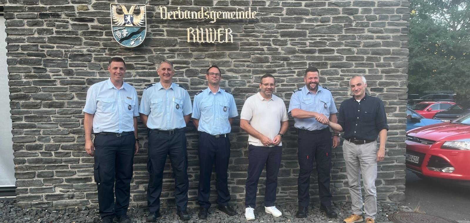 Der VG-Bürgermeister Thomas Hoffmann, Beigeordneter Dirk Bootz, Wehrleiter Frank Rohde sowie 3 weitere Personen von der Feuerwehr lächeln in die Kamera.