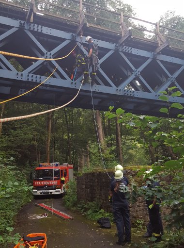 Feuerwehrmann seilt sich von Brücke ab