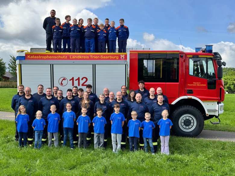 Feuerwehrmannschaft vor einem Feuerwehrauto 