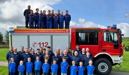 Feuerwehrmannschaft vor einem Feuerwehrauto