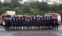 Feuerwehrmänner vor Feuerwehrautos