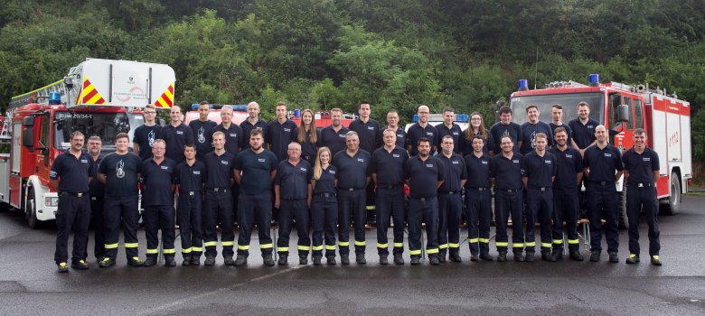 Feuerwehrmänner vor Feuerwehrautos