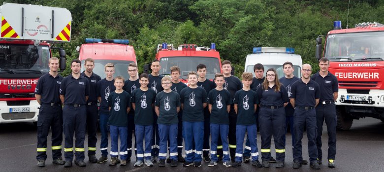 Jugendfeuerwehrgruppe vor Feuerwehrautos