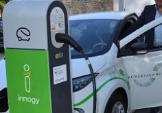 Gruppenfoto Elektrofahrzeug Elektroladestation mit Elektrofahrzeug und vielen Menschen