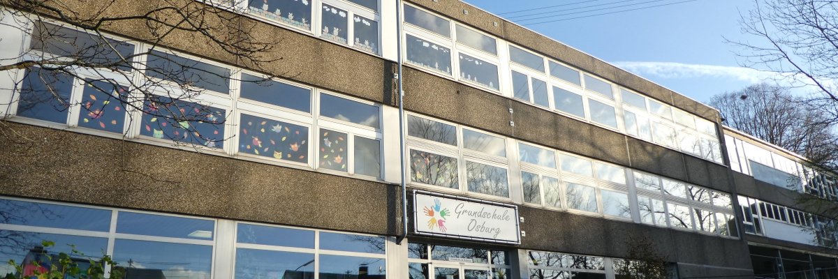 Schulgebäude mit langen Fensterfronten und Eingang
